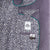 Close-up of a patterned shirt with a brand label on a textured fabric background