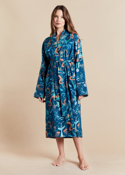 Woman wearing a blue patterned lightweight robe on a beige background
