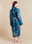 Woman wearing a blue patterned lightweight robe on a beige background
